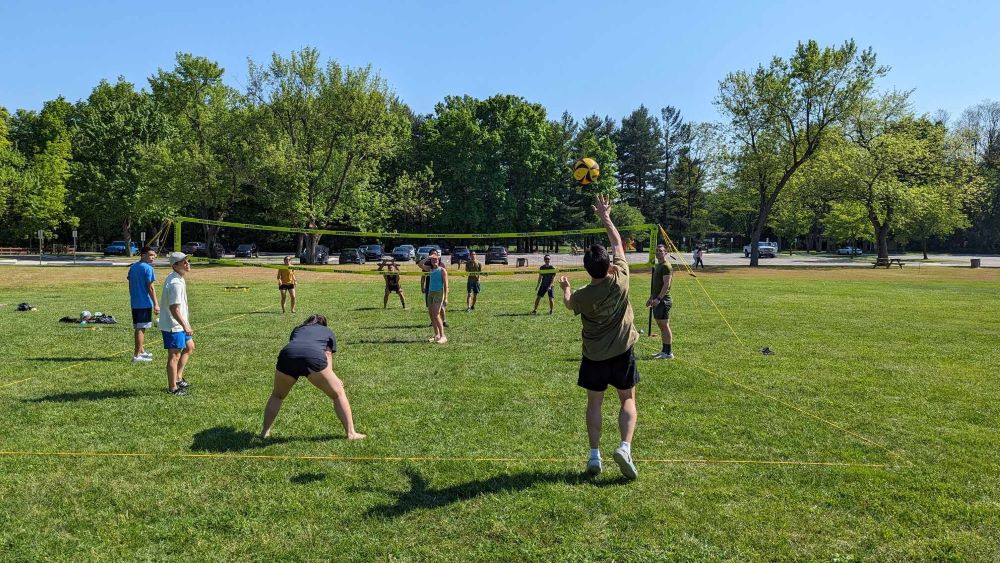 playing grass volleyball at a picnic. Bringing back the memories of playing volleyball together in college.